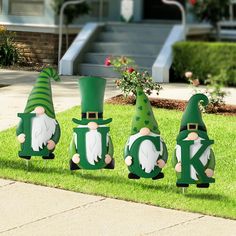 three garden gnomes are standing in the grass with their letters k and o on them