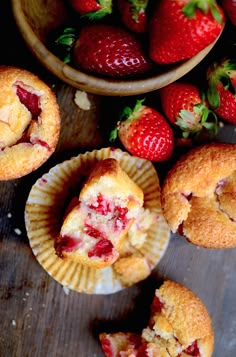 strawberry muffins with one cut in half and the rest on the table next to it