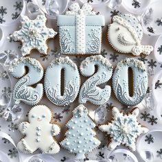 decorated cookies in the shape of numbers and snowflakes on a white tablecloth