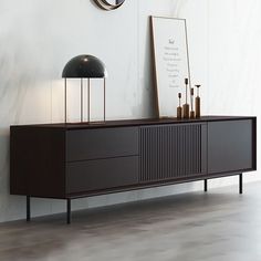 a sideboard with a clock on the wall behind it