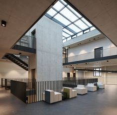 an empty building with several tables and chairs in front of a staircase that leads up to the second floor