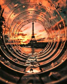 the eiffel tower is seen through water droplets