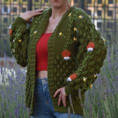 a woman wearing a green knitted cardigan with flowers on it