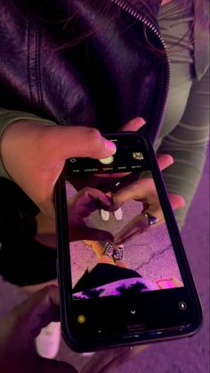 a woman is holding up her cell phone