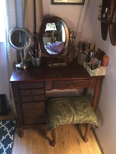 a vanity with a mirror, stool and other items