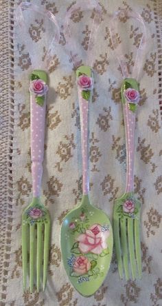 three green and pink plastic utensils with roses on them