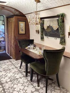 a dining room table with two chairs and a chandelier