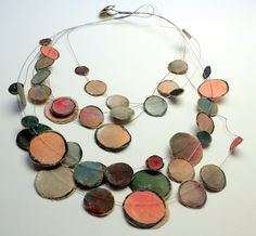 a multicolored necklace is displayed on a white surface, with strings attached to it