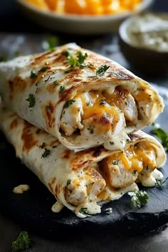 two quesadillas stacked on top of each other with cheese and vegetables in the background