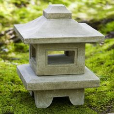 a stone lantern sitting on top of a lush green field