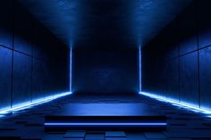 an empty dark room with blue lights on the ceiling and floor tiles in the floor