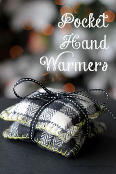 two small black and white pillows with the words pocket hand warmers on top of them