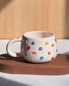 a white coffee cup sitting on top of a wooden tray