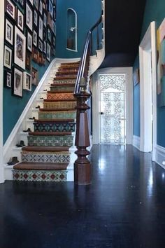 a staircase with pictures on the wall next to it