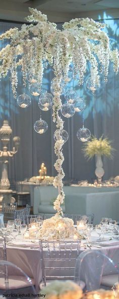 an image of a table setting with flowers and hanging bubbles on it's centerpiece