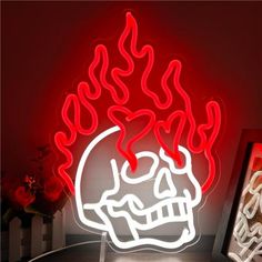 a lit up skull with flames on it's head next to a framed photograph