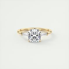 a yellow and white gold engagement ring with an oval cut diamond in the center, two baguets on each side