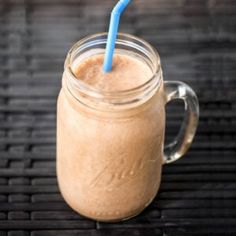 a glass mug with a blue straw in it