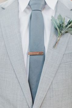 a man wearing a suit and tie with a boutonniere on his lapel