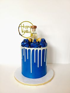 a birthday cake with blue icing and gold decorations