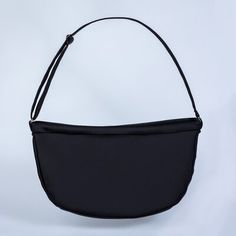 a black handbag on a white background with a strap around the bottom and shoulder