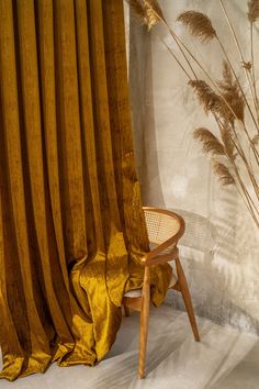 a chair sitting next to a yellow curtain