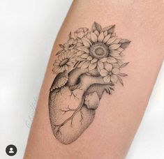 a sunflower and heart tattoo on the right thigh, with flowers in the middle