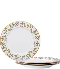 three plates with holly designs on them and gold trimming around the edges, one plate has