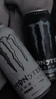 two cans of monster energy drink sitting next to each other