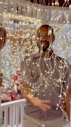 a man standing in front of a window covered in lights