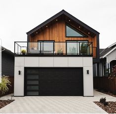 a modern house with two garages and a balcony on the second floor is shown