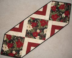 a red and white quilted neck tie with floral designs on it's side