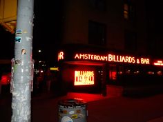 a sign that is on the side of a pole in front of a building at night