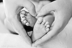 a baby's feet being held in the shape of a heart with two hands