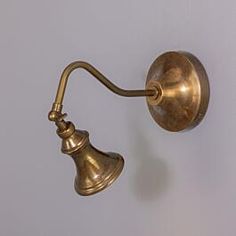 an old fashioned brass wall light on a white wall in a room with grey walls