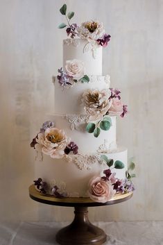 a three tiered wedding cake with flowers on it