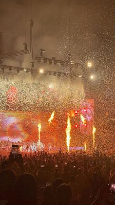 a large group of people standing on top of a stage covered in confetti