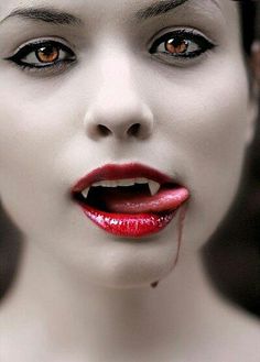 a woman with blood on her face and red lips is posing for the camera while wearing white makeup