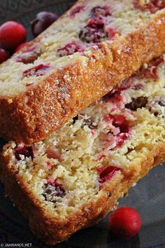 two loafs of cranberry bread sitting on top of a plate with berries