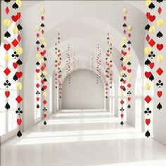 an image of a hallway with playing cards hanging from the ceiling and balloons in the air