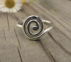 This listing is for a single sterling silver hand made spiral ring. The band of the ring is 1.5mm wide, while the spiral itself is lightly hammered flat and measures 1 cm across. Spirals are one of the oldest symbols found all over the world in ancient art and jewellery, when you see how beautifully it works as a ring, it's easy to see why. These are individually hand forged from sterling silver wire before being hammered and polished to a high shine. As they are forged rather than cast, these r Single Wire Ring, Cheap Handmade Silver Rings, Flo Outfits, Body Decoration, Right Hand Ring, Spiral Ring, Right Hand Rings, Dope Jewelry, Hand Ring