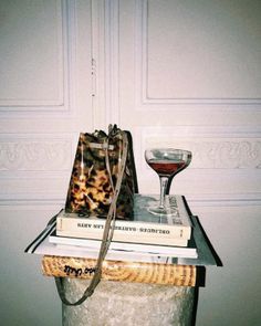 a stack of books and a wine glass on top of each other in front of a door