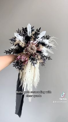 a person holding a bouquet with feathers on it