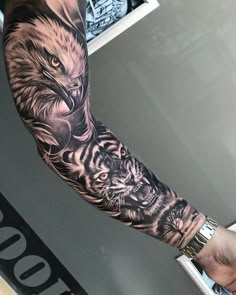 a man with a tiger and eagle tattoo on his arm, both holding hands together