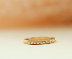 Cherished Gold Ring
With a delicate confetti beaded pattern surrounding the entire band, she's a reminder you're cherished. You cherish those you love most.  Beautiful crafted stacking ring perfectly pairs with other Erin Pelicano rings, or as a band worn in her own beauty. Stack one for each child, stack one for each of your favorite people, collect one for each milestone, or wear as your wedding band.

Designed and crafted in solid 14k gold, choose from white, yellow, or rose gold.

 	14k Heirloom Style Stackable Eternity Band, Heirloom Style Stackable Round Eternity Band, Heirloom Stackable Round Eternity Band, Promise Jewelry With Decorative Round Band, Fine Jewelry Stackable Promise Rings With Decorative Band, Fine Jewelry Stackable Decorative Band Rings For Promise, Heirloom Style Stackable Diamond Cut Rings For Promise, Heirloom Stackable Rings With Decorative Band, Promise Stackable Halo Rings