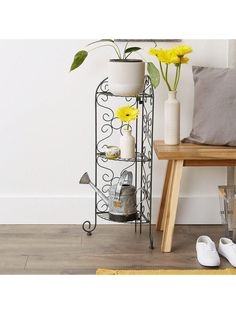 a shelf with yellow flowers in it next to a pair of slippers and shoes