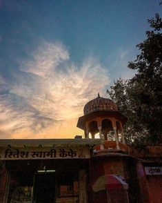 the sun is setting over an old building