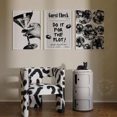 a black and white cat sitting on top of a chair in front of two pictures