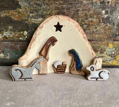 a nativity scene with three figurines in the shape of animals and a star