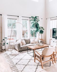 a living room filled with furniture and large windows